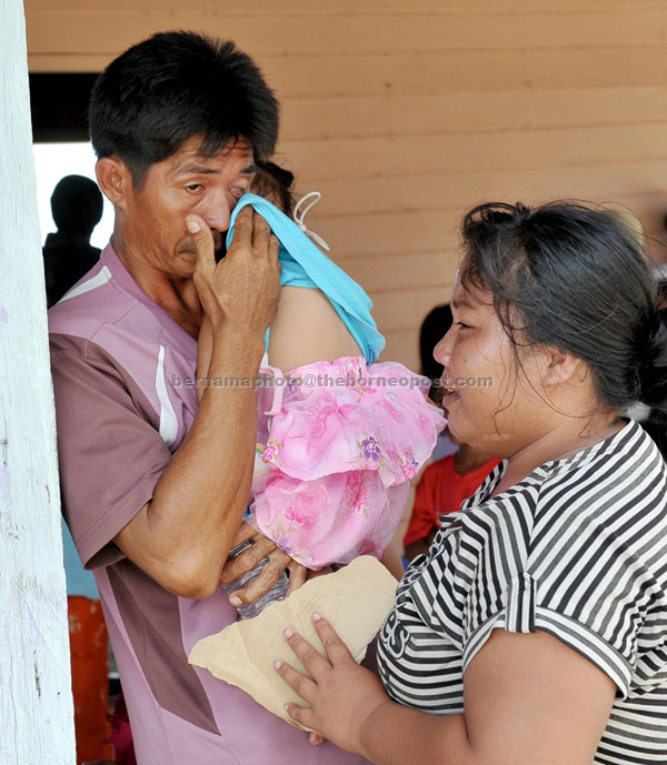 HOUSE GONE: A couple cries after learning that their house was razed by fire during a gun battle with the terrorists. — Bernama photo