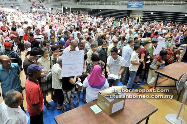 DEDAT: Penerima BR1M3.0 ari Parlimen Bandar Kuching enggau Stampin nedat Stadium Tertutup MBKS ngambi baucher diri.