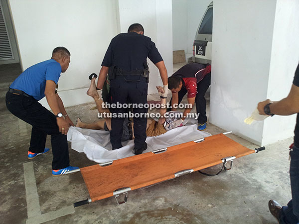 TERJATUH: Mayat Kho diangkat oleh anggota polis sebelum dihantar ke HUS untuk bedah siasat. 
