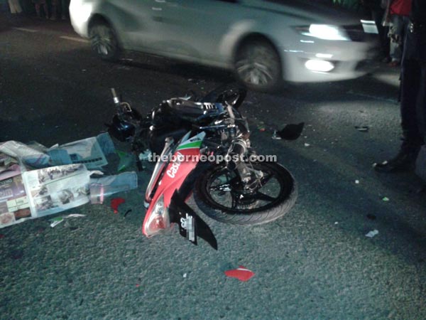 The victim's covered body and his motorcycle at the scene of the accident.