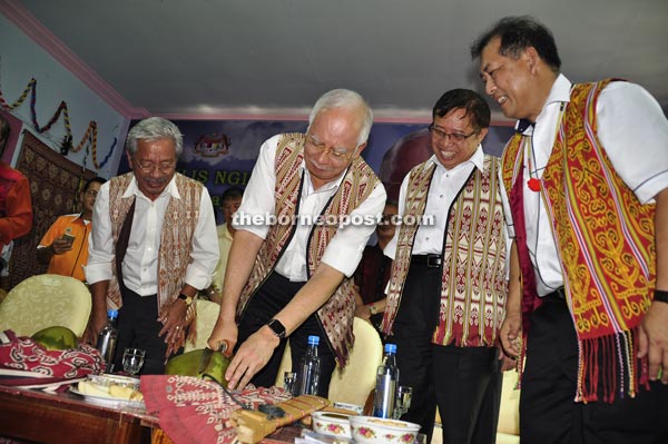 Najib performs the ‘naku buah inyak’ (cutting the coconut) as (from right) Ugak, Abang Johari and Masing look on.  