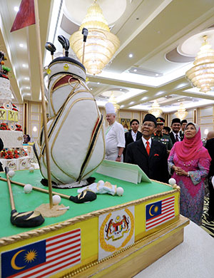 Tuanku Abdul Halim (second right) and Tuanku Hajah Haminah taking a closer look at a ‘Golf’ themed cake from Hilton Hotel Kuala Lumpur. — Bernama photo