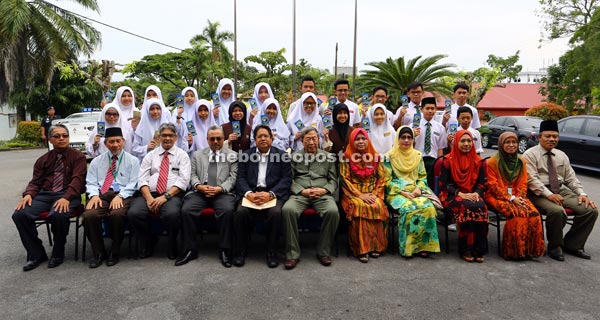 Bujang Nor (seated, sixth right) and his entourage joining Kolej Abdillah teachers and students for a group photo.— Photo by Muhammad Rais Sanusi