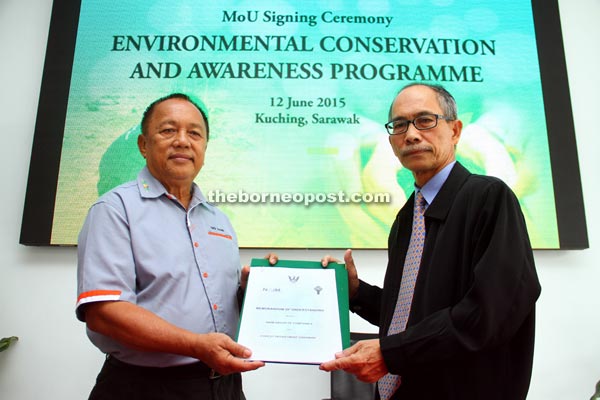 Said (right) and Abg Hasni exchanging the MOU documents. — Photo by Chimon Upon