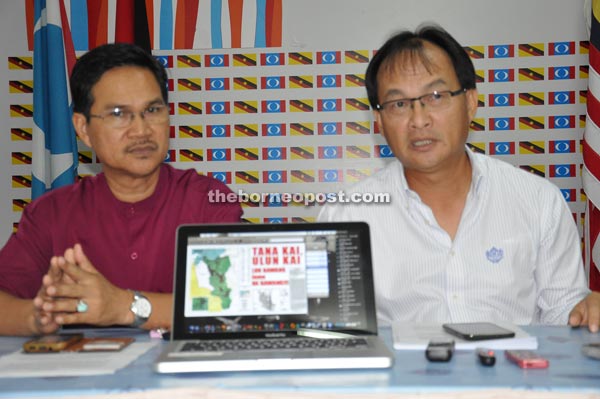 Baru (right) showing the map of the affected areas and their rallying cry in defending their lands during the press conference. On the left is state PKR deputy chairman Abang Zulkifli Abang Engkeh.