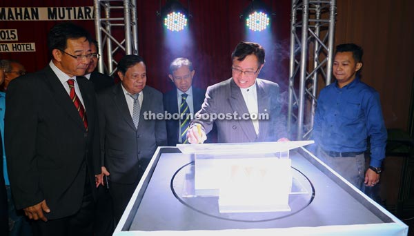 Abang Johari (second right) appends his signature on the logo of Mutiara Mortgage & Credit Sdn Bhd. — Photo by Muhamad Rais Sanusi