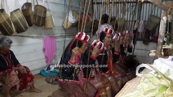 Female shamans reciting prayers to their deities at the village’s ‘Boli Gawea’ while sitting on a swing.
