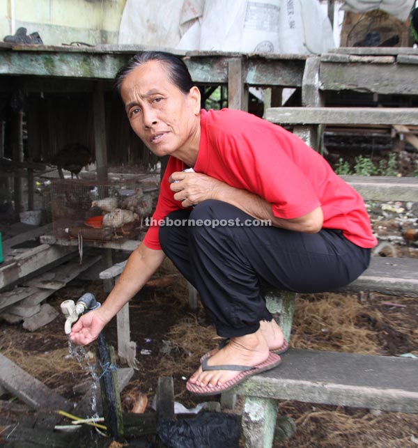 Lihut proudly showing the tap water outside the house of her parents-in-law.