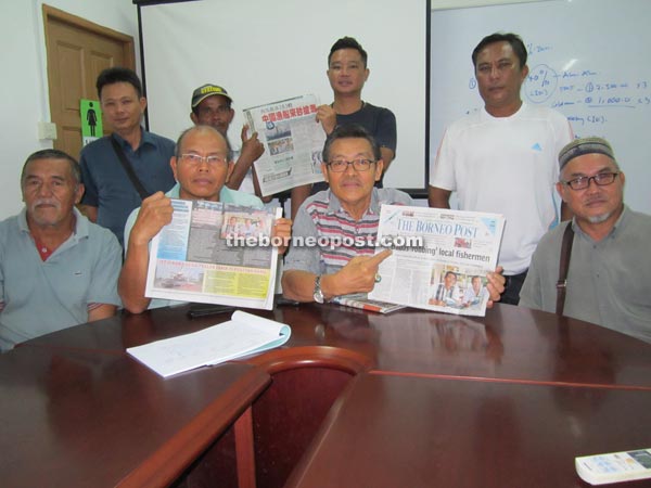 (Seated second right) Councillor Jamali Basri shows The Borneo Post report on Ali Babas that was front-paged yesterday.