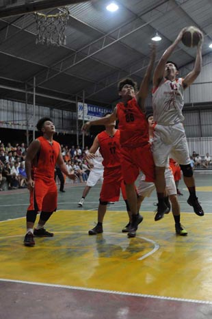 Friends attempting to block an Isotimber player. Isotimber prevailed 66-62 to lift the Sibu Open title. — Photo by Helen Tang.