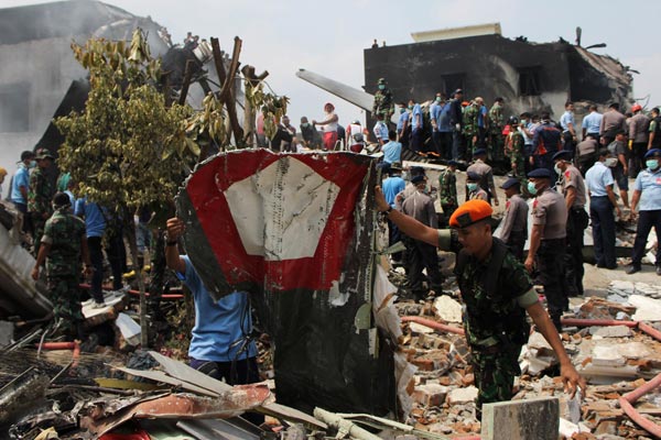 Military personnel retrieve wreckage bearing the Indonesian Air Force roundel. — AFP photo