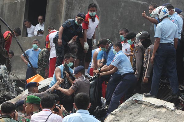 FILE PHOTO: Indonesian rescue personnel retrieve a body from the scene of the crash. — AFP photo