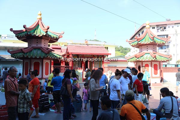 People crowding at the walkway in front of the market located next to the Tua Peh Kong temple.