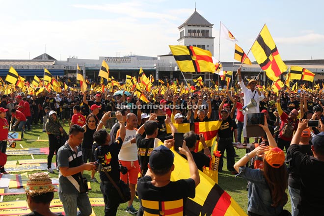 The huge crowd proudly waving the old Sarawak flags. 
