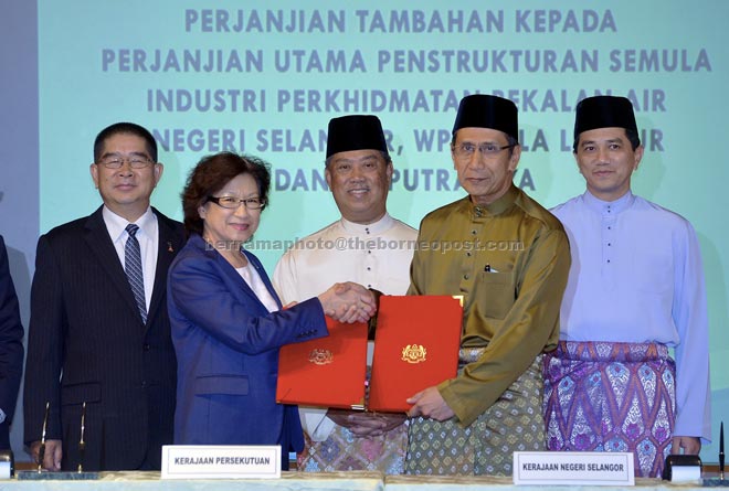 Muhyiddin (centre) witnessing the exchange of documents between Loo and Mohammed Khusrin. Looking on are Ongkili (left) and Azmin.— Bernama photo 