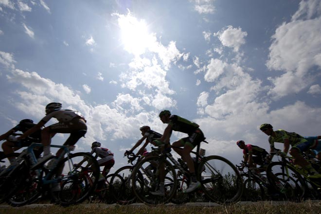 The pack is seen in silhouette as it rides during the 178.5-km 14th stage of the 102nd Tour de France cycling race from Rodez to Mende, France. — Reuters photo