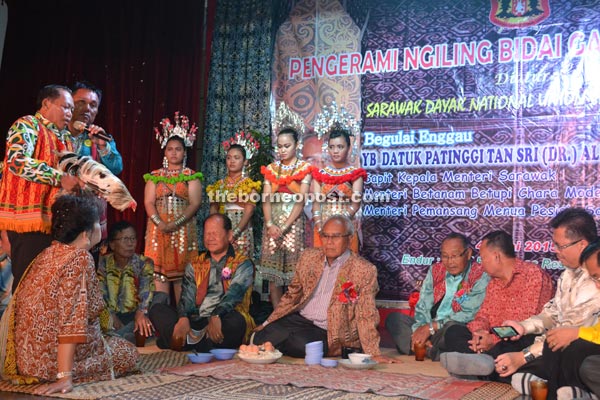 Jabu (seated centre) joins others at the miring ceremony.