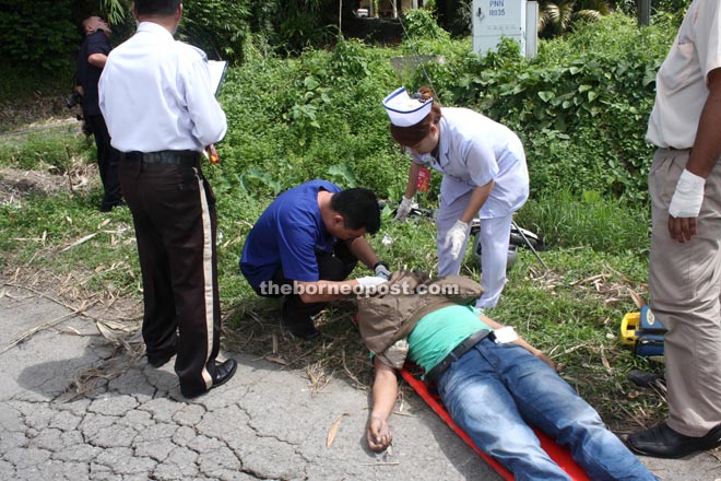 Medical personnel checking the victim for possible signs of life at the accident scene.