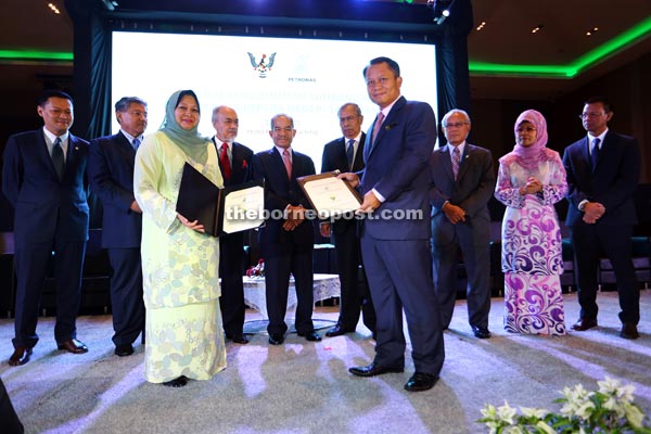 Petronas Group Human Resource Management senior vice president Datuk Raiha Azni Abdul Rahman (third left) and Yayasan Sarawak director Datu Mohamad Abu Bakar Marzuki (fourth right) with their MoU for the enhancement of technical skills via Vista. Witnessing the exchange are Adenan, Jabu (third right), Morshidi (second left), Asfia (fourth left), Fatimah (second right), and Sidek (fifth left).  