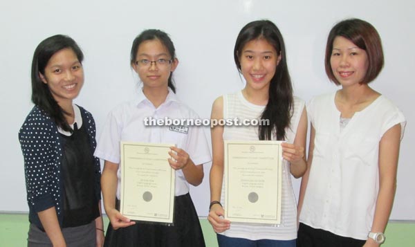 (From second left) Jia Sing and Elisia hold their certificates while the centre’s teaching personnel Alisya Hon and Jacqueline Lo look on. 