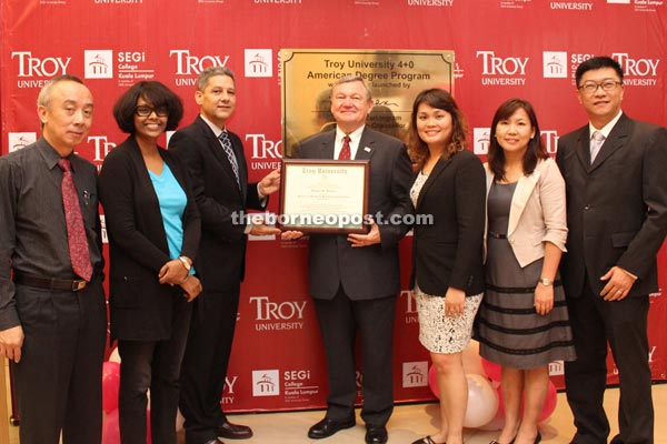 Ingram receives a memento from Antonides (third left) in recognition of the partnership between the two higher learning institutions. Also seen are (from left) Kee, Doris, Lau, Chok and See.