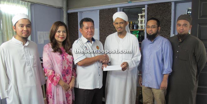 Alexander (third left) handing over his personal donation to Afendi in the presence of the school’s committee members (from left) Muhd Iskandar, Alexander’s wife Susan Clement, Sumardi Ghazalee and Umar Usaini at Madrasah Darul Uloom Islamiayyah in Kuching yesterday.