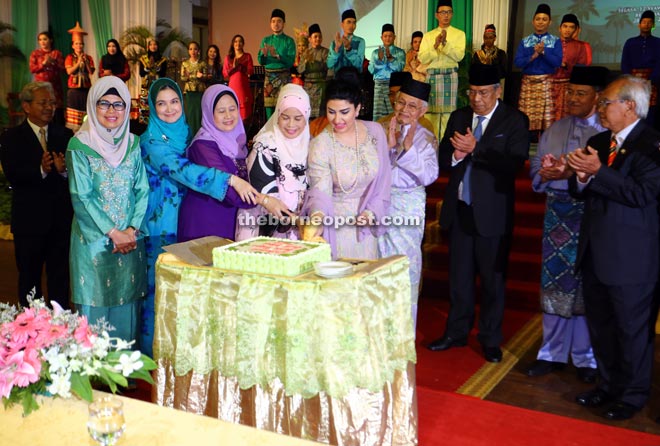 Ragad (fifth left) cutting the Raya cake with (from her right) Jamilah, Morshidi’s wife Puan Sri Datin Amar Saptuyah, Asfia’s wife Datin Amar Faitmah Mohd Iskandar and Fatimah   while Taib, Adenan, Morshidi and Jabu look on. - Photo by Muhammad Rais Sanusi