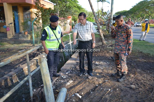 Lee (centre) getting information on the gas pipeline burst from the police and firemen at the scene.