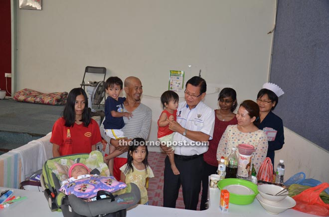 Lee holding one of Masudi’s children, accompanied by (from right) Renyam, Nurin and Dr Marianne. 