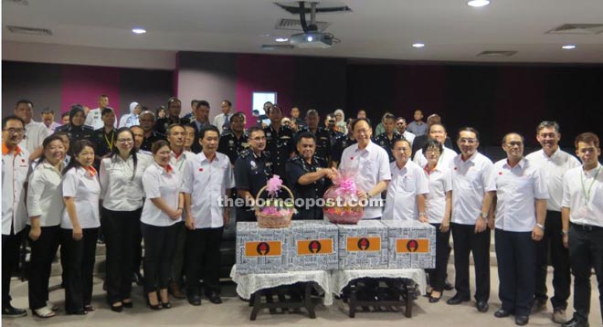 Teo (seventh right) presents Raya goodies to State Deputy Police Commissioner Datuk Awang Sahari EM Nadzeer. 