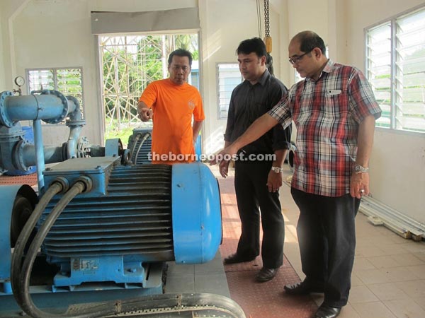 (From left) JKR Dalat water treatment plant technician Mohd Sahari showing the pumps to Kilat and Sait.