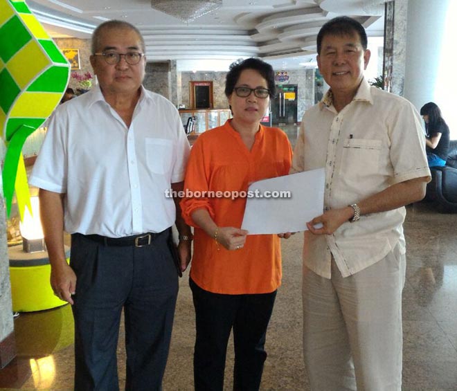 A SMK Lutong PTA representative hands over a copy of the appeal letter to  Ting (right). With them is SUPP Pujut Branch chairman Adam Yii.