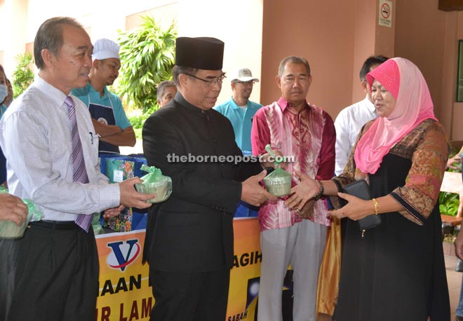 Yahya (second left) distributes the bubuk lambuk at Wisma Pertanian while Yeo (left) looks on. 