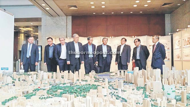 Adenan (fourth left) looks at a model of Singapore city during one of the tours. He is seen with Lo (second left), Awang Tengah (third left), Morshidi (fourth right) and Abang Johari (third right).