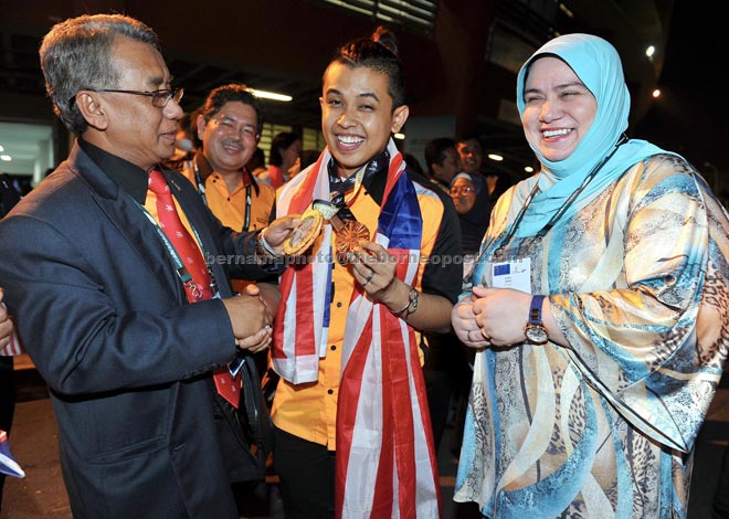 Deputy Human Resource Minister Datuk Seri Ismail Abd Mutallib (left) and Deputy Works Minister Datuk Rosnah Abdul Rashid Shirlin (right) having a light moment with Airul after win the Bronze medal in Hairdressing during the closing ceremony and prize giving  World Skills Sao Paulo 2015 at Ibirapuera Gymnasium in Sao Paolo. — Bernama photo 