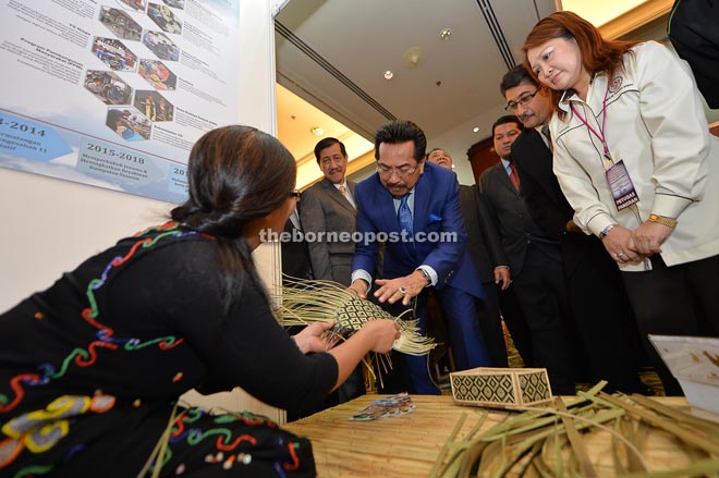 Musa taking a closer look at a handicraft during his visit to the Sabah Foundation exhibition booth after declaring open a course for board of directors in government statutory bodies and agencies at Magellan Sutera yesterday. ay. 