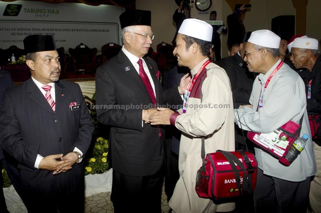 Najib (second left) shaking hands with the pilgrims when seeing off the sixth batch of 279 pilgrims at the Tabung Haji Complex in Kelana Jaya. — Bernama photo