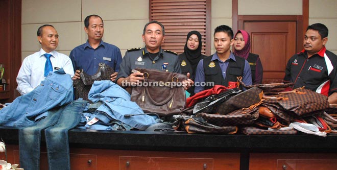 Yahya (third left) showing the imitation branded goods that were seized in the operation.