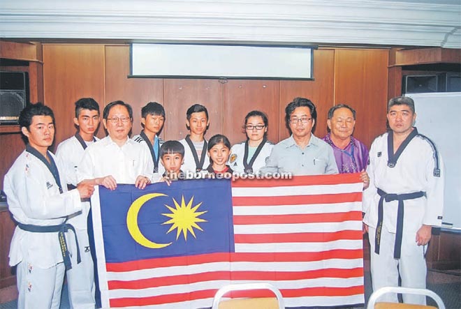 Lau (front row, second left) hands over a flag to team manager Albert Wong. At second right is RTC chief coach Thomas Tang.