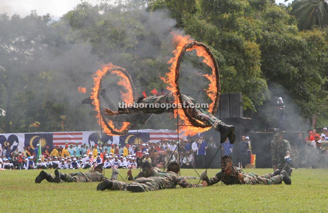 A soldier jumps through rings of fire during the state-level National Day celebration in Limbang.