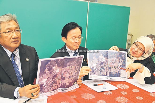 Rodziah (right) together with Chok (centre) and Bintulu resident Yakup Kari showing the map depicting flood prone areas in Bintulu.