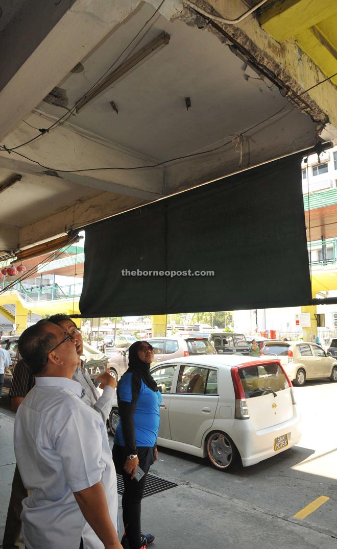 Abidin taking a closer look at the loose concrete on the overhead bridge at Segama shopping area.