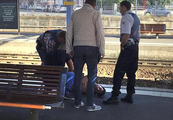 File photo shows French police stand over a man who was apprehended on the platform at the Arras train station after shots were fired on the Amsterdam to Paris Thalys high-speed train where several people were injured in Arras, France. — Reuters photo