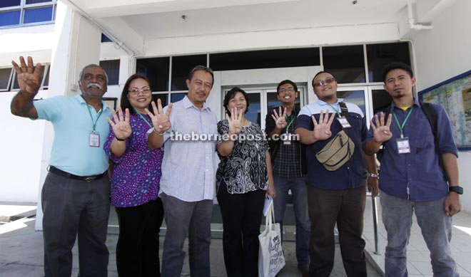 Jannie (fourth left), Muthu (left), organizing committee members and Bersih Sabah committee make the ‘four’ sign to represent the Bersih 4 overnight rally outside the   Karamunsing police station.