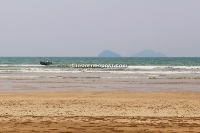 A fishing boat spotted riding the waves at Sematan beach with Talang-Talang at the background.
