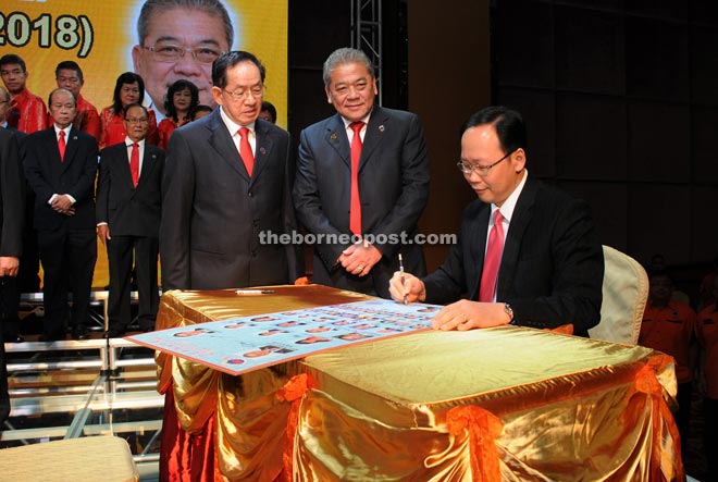 Teo (seated), who represents Musa, officiates at the FCAS swearing-in ceremony. He is flanked by association president Goh (middle) and deputy president Datuk Jimmy Yong Kyok Ming (left)