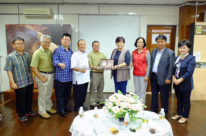 Oswald (fifth left) presenting an adoption certificate of Digital Guro to Kim, witnessed by Chan (fourth left) and others.