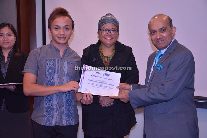 Venkat (right) presents certificate of participation to Jude Toyat, a reporter with  The Borneo Post Seeds by BPOnline. Also seen is Wee (centre).