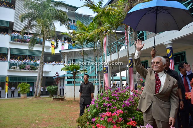 Taib waving at cheering students at Kuching High School from their courtyard during the official opening of their new administration and classroom blocks.