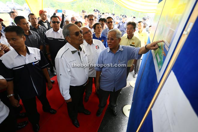 Manyin briefs Adenan (second left) on the road project.